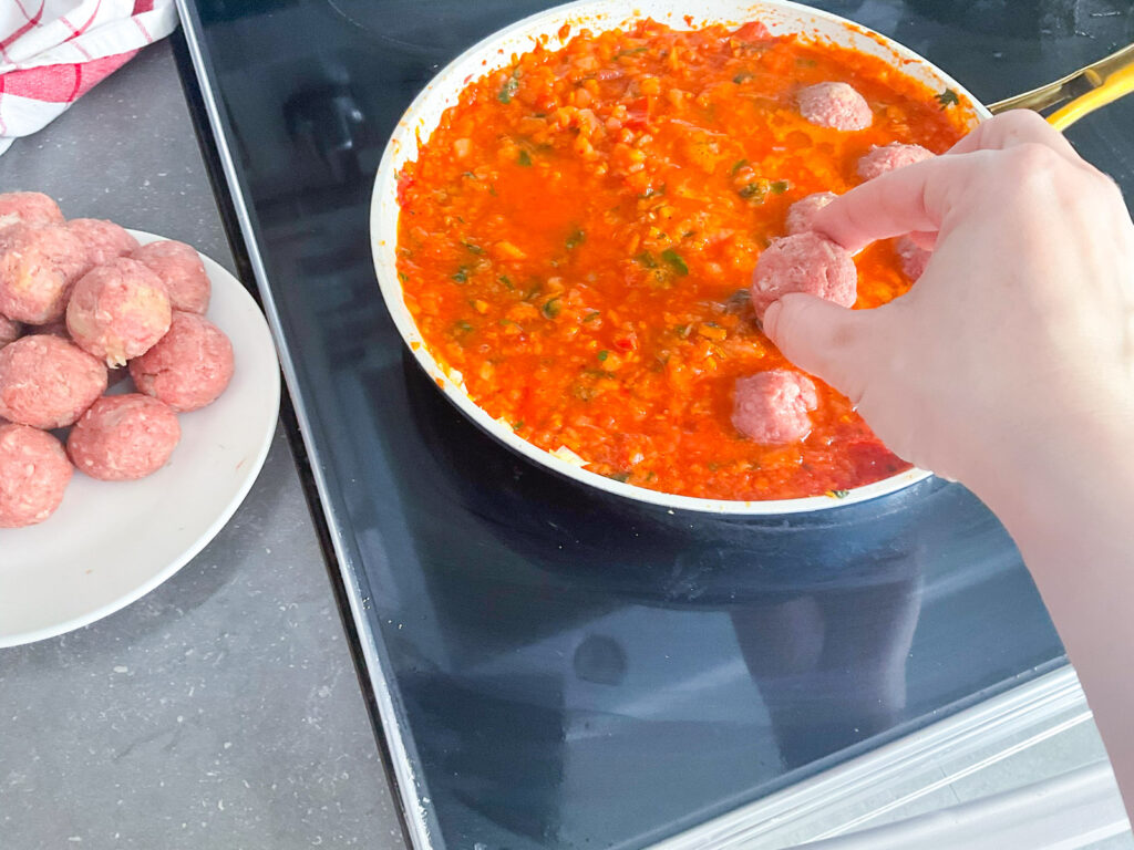 Déposer les boulettes directement dans la sauce chaude. Laisser mijoter à feu doux jusqu’à ce que les boulettes soient bien cuites et tendres.