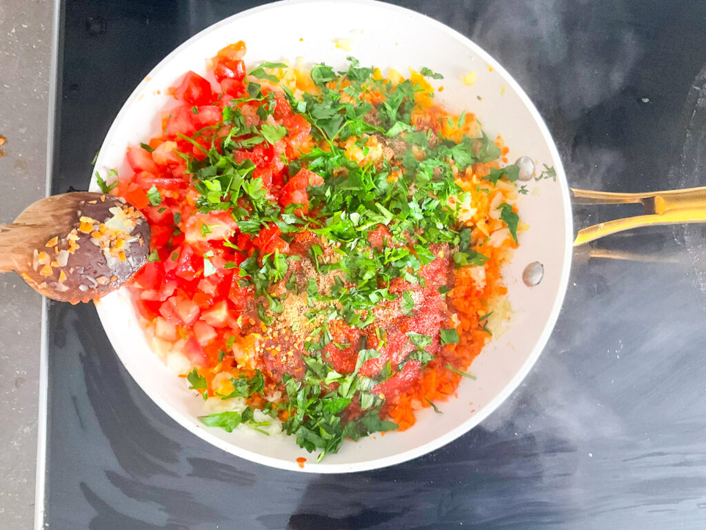 Incorporer les tomates fraîches coupées, les herbes et les épices, puis bien mélanger.