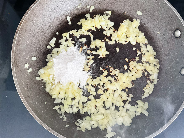 Incorporer la farine et bien mélanger pour enrober les oignons.
