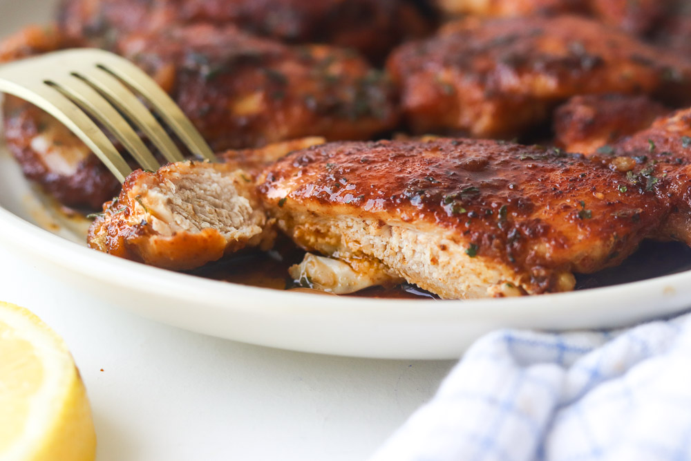 Hauts de cuisses de poulet à l'ail à la poêle nappés d'une sauce savoureuse, avec une texture tendre et juteuse à l'intérieur.