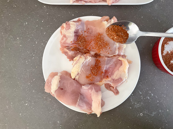 Mélange d'épices réparti sur les hauts de cuisses de poulet