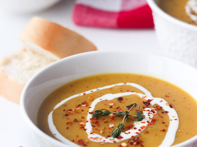 Velouté de légumes lisse avec lentilles rouges, accompagné de pain et d’un linge de cuisine