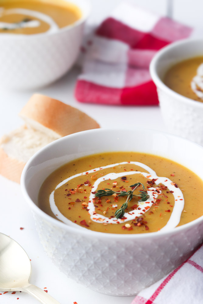 Velouté de légumes lisse avec lentilles rouges, accompagné de pain et d’un linge de cuisine