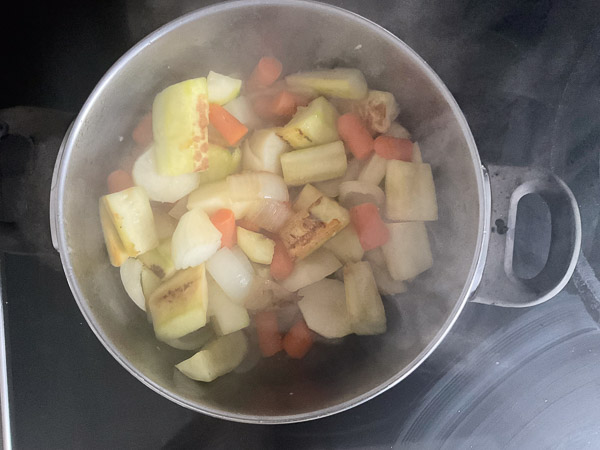 Légumes en train de cuire dans une casserole avec oignon et ail pour préparer un velouté