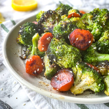 Gros plan sur une poêlée de brocoli et de carottes au miel garnie de graines de sésame, offrant une texture tendre et légèrement croquante.