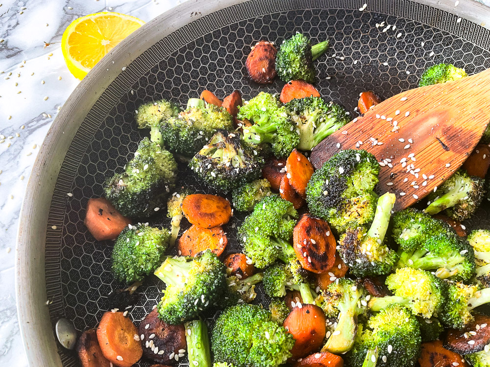 Poêlée de brocoli et de carottes caramélisés au miel, garnis de graines de sésame et cuits jusqu'à ce qu'ils soient tendres et légèrement croquants.

