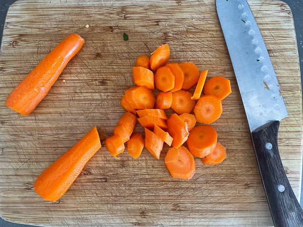 Carottes nantaises coupées en rondelles d'environ 1 cm d'épaisseur sur une planche à découper.