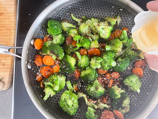 Miel versé sur des carottes et du brocoli cuits à la poêle pour enrober les légumes d'une touche