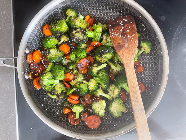 Carottes et brocolis au miel et aux graines de sésame prêts à servir après avoir été assaisonnés de sel et de poivre.