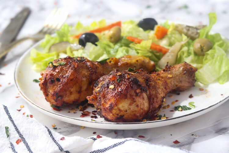 Pilons de poulet croustillants à l'air fryer accompagnés d'une salade verte fraîche.