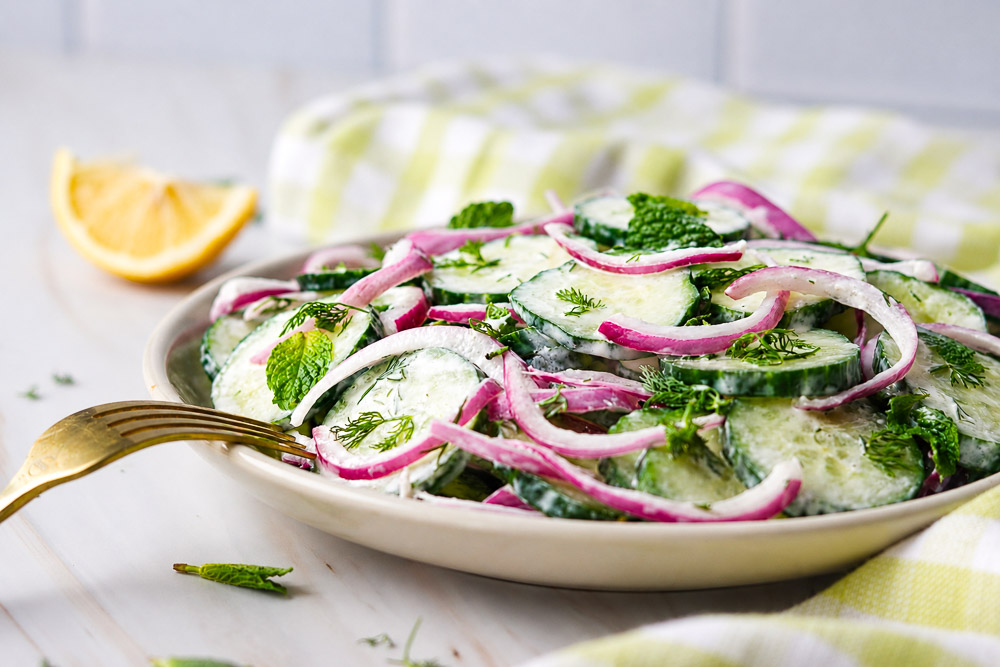 vue de face d‘une salade de concombres et oignons rouges avec sauce crémeuse a l aneth
