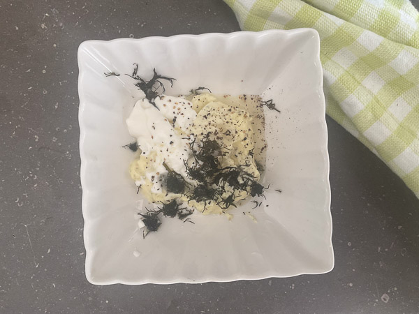 Sauce assaisonnée avec de l’aneth, du sel et du poivre avant d’être mélangée.