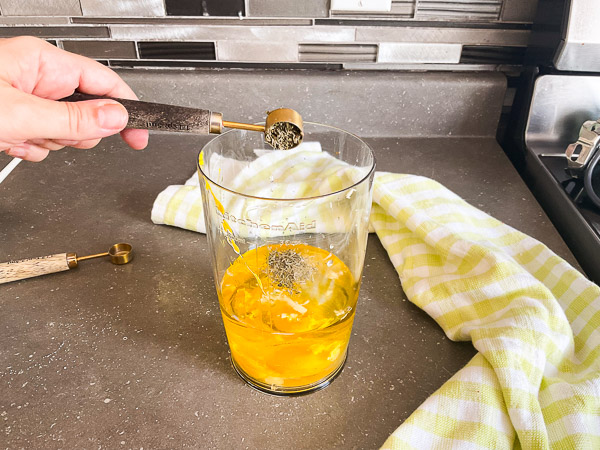 Ajout de thym séché aux ingrédients de la mayonnaise maison à l'huile d'olive.