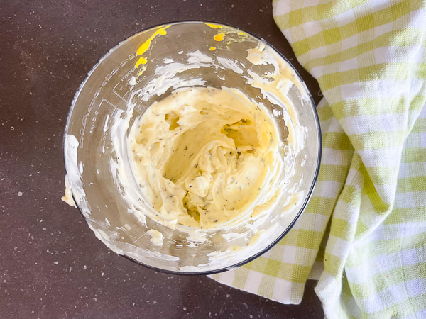 Mayonnaise maison à l'huile d'olive et au thym presque terminée après l'émulsion complète des ingrédients au mélangeur à immersion.