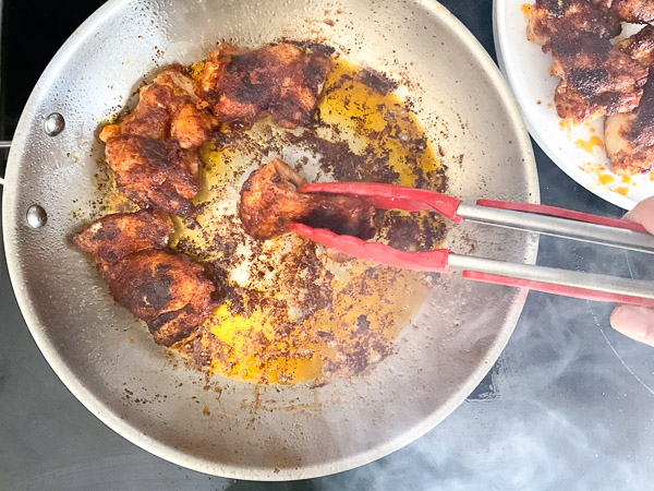 Retrait du poulet doré de la poêle avant la préparation de la sauce crémeuse épicée