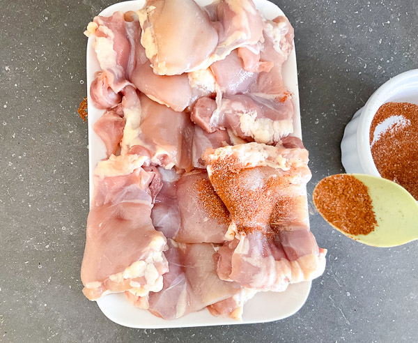 Assaisonnement des hauts de cuisse de poulet avec le mélange d’épices
