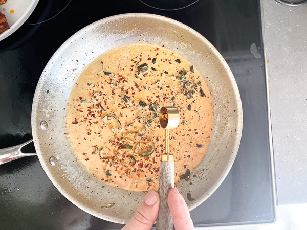 Mélange de la sauce crémeuse avec les jalapeños et les flocons de piment rouge