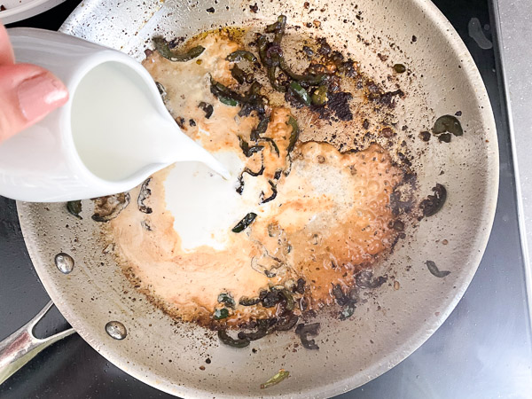 Ajout de la crème dans la poêle pour déglacer les sucs de cuisson et préparer la sauce