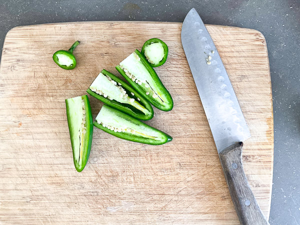 Jalapeños coupés en deux sur une planche à découper avant le retrait du cœur et des graines