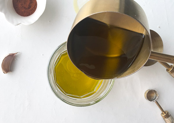 Étape 4 – Huile d’olive versée dans le bocal pour préparer une vinaigrette maison au paprika fumé.
